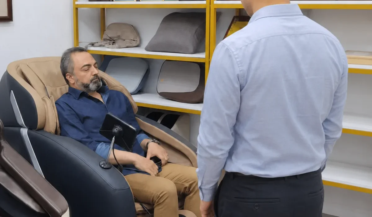 Comprador evaluando un sillón de masaje en una sala de exposición